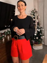 Blusa de gasa negra con mangas largas plisadas.