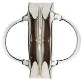 Cartera de hombro Guess modelo Isobel, color blanco, con estructura rígida y cierre superior. Presenta un dije colgante en forma de corazón con logo metálico y herrajes dorados.