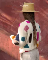 Buzo tejido a mano de lana 100% merino, color off-white con diseño de formas geométricas abstractas y coloridas de estilo artesanal, con cuello redondo y mangas largas.