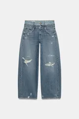 Jeans de tiro medio con cinco bolsillos, cintura doble a contraste y detalles de rotos. Cierre frontal con cremallera y botones metálicos.