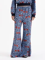 Pantalón de corte relajado y fluido, confeccionado en viscosa estampada con diseño de corazones rojos sobre fondo azul con manchas oscuras. Presenta cintura elástica, bolsillos laterales y bandas laterales con vivos en contraste.