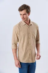 Camisa de lino de manga larga en color beige, con cuello camisero, cierre frontal de botones y un bolsillo ojal en el pecho.