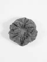 Gomita tipo scrunchie de tela negra cubierta de pequeños strass brillantes.