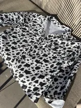 Camisa de denim con estampado de manchas de vaca, corte recto y cierre frontal con botones.