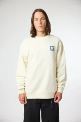 Buzo de cuello redondo color crema, con un pequeño parche cuadrado azul marino con una 'X' blanca en el pecho.