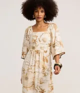 Vestido midi evasê de Marfinno, confeccionado en mezcla de viscosa y lino, con estampa de mapa en tonos beige y tostado sobre base off-white. Presenta escote cuadrado, mangas amplias con detalles bordados en los bordes y corte fruncido en la cintura.
