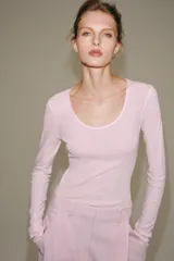 Camiseta de manga larga color rosado, de corte regular con escote redondo amplio y bajo recto.