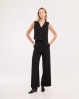 Chaleco de vestir gris oscuro con textura tipo tweed, escote en V y botones frontales. Corte levemente entallado y largo a la cintura.