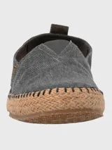 Alpargatas Hush Puppies modelo Hubert, color negro, con suela de yute trenzado y costuras decorativas. Diseño slip-on con elástico en el empeine.