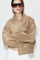 Chaqueta de efecto ante con cuello solapa envolvente, manga larga con hombro caído y bajo con elástico interior. Cuenta con bolsillos laterales ocultos en costura y forro interior.