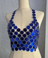 Top tipo corpiño confeccionado con círculos metálicos unidos por pequeñas cadenas, color azul eléctrico. Se ajusta con cadenitas en la espalda y el cuello.