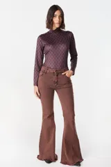 Pantalón de jean azul oscuro, corte acampanado (flare) de tiro alto, con costuras visibles en contraste y bordados tonales en la parte inferior de las piernas. El ruedo es deshilachado.