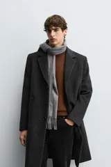 Abrigo regular fit de color negro, confeccionado con mezcla de lana y cashmere. Presenta cuello con solapas de muesca, manga larga, bolsillos de vivo en la cadera, abertura central en la espalda y cierre frontal de botonadura con tres botones.