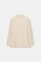Blazer de Zara Woman Collection confeccionado en mezcla con lino, color beige con diseño de rayas finas verticales. Presenta cuello solapa, manga larga, bolsillos de parche en el delantero y cierre frontal con botones oscuros a contraste.