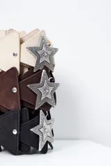 Cinto marrón de cuero con apliques triangulares y hebilla metálica con forma de estrella.