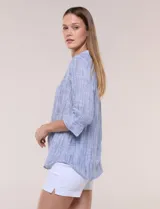 Blusa de silueta relajada con textura tramada, color azul con rayas verticales en tonos rosados, celestes y amarillos. Cuenta con cuello mao abierto en V y mangas tres cuartos amplias con pequeña abertura lateral en el puño.