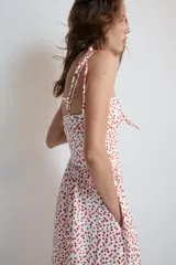 Vestido midi de popelina blanco con estampado de lunares rojos, escote corazón, tirantes finos con lazo y detalle de nudo en el busto.