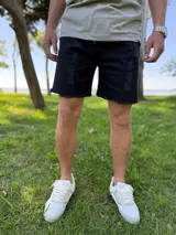 Bermuda de jean color negro con roturas y detalles deshilachados en el dobladillo y bolsillos, estilo jogger.