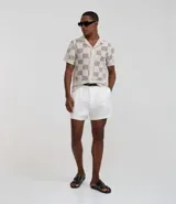 Camisa de manga corta con cuello inglés y abotonadura frontal. Diseño con encaje bicolor texturizado en tonos beige y blanco. Corte regular.