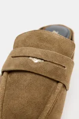 Mocasín destalonado de serraje color marrón, con copete subido, antifaz delantero con detalle metálico y punta cuadrada.