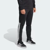 Pantalón deportivo Adidas de corte cónico, color negro con las icónicas tres tiras blancas en los laterales. Cuenta con cintura elástica con cordón de ajuste, bolsillos laterales con cierre y cierres en los tobillos para mayor practicidad.