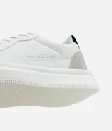 Championes urbanos blancos de material sintético con detalles en gris y negro. Presentan punta redonda, cordones, perforaciones para mayor respirabilidad y suela bold.