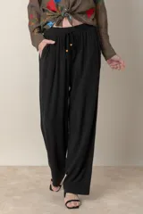 Pantalón ancho negro de lino y rayón, con cintura elastizada ajustable con cordón y bolsillos laterales.