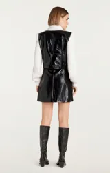 Campera negra de cuero sintético con mangas largas de punto acanalado color crema.