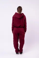 Campera tipo hoodie con cierre frontal, de corte cropped y color bordó. Presenta detalles de líneas blancas en las mangas y un bordado pequeño en el pecho.