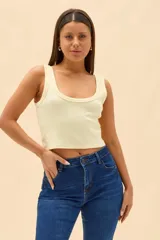 Top crop de tejido rib color amarillo claro, con escote redondo pronunciado y tirantes anchos.