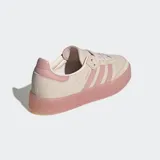 Championes Adidas Sambae, una versión actualizada del modelo Samba con una suela elevada y gruesa de color rosado translúcido. El exterior es de cuero nobuk color beige claro con las 3 rayas dentadas y refuerzo en la puntera en color rosado pálido.