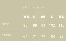 Vestido corto estilo campero, color camel, con tirantes finos trenzados. El ruedo tiene un detalle de volado de tela clara asomando por debajo.