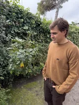 Sweater azul marino de lana con cuello redondo y logo bordado en rojo en el pecho. Corte holgado.