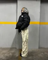 Pantalón de jean color crema con estampado abstracto en tonos marrones, de corte recto y tiro alto.