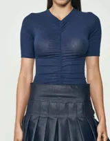 Blusa azul de mangas cortas con escote en V y frunces en el centro.