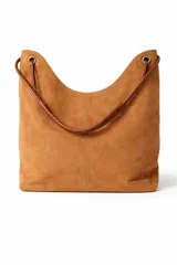 Cartera tipo hobo de gamuza color tostado, con diseño minimalista y costura central vertical. Cuenta con una correa de hombro de cuero liso en tono marrón oscuro, sujeta mediante argollas metálicas.