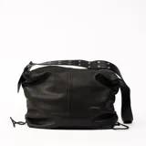 Bolso tipo hobo de cuero negro con textura granulada, cierre superior con cremallera y correa de hombro ajustable con apliques metálicos.