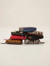 Billetera compacta con cierre perimetral, confeccionada en cuero con diversas texturas y estampados, incluyendo animal print y cuero liso.
