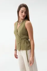 Chaleco cruzado sin mangas de gasa texturizada color verde militar, con escote en V y tiras para atar en el lateral.