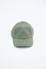 Gorra verde militar de diseño clásico con visera curva y bordado frontal en hilo rojo con la palabra "UNIFORM".