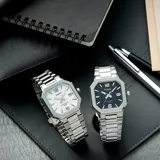 Reloj analógico Casio con caja octagonal de acero inoxidable y malla de eslabones plateada. Presenta una esfera blanca con índices aplicados, números 12 y 6, y ventana de calendario a las tres.