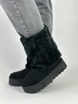 Botas negras de caña media con plataforma y detalle de piel sintética en la parte superior.