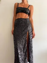 Pollera larga negra cubierta de lentejuelas, con tajo lateral alto.
