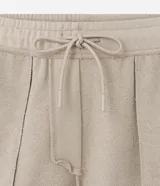 Bermuda masculina color marrón oscuro, confeccionada en tela French Terry, con cintura elástica y cordón de ajuste. Presenta bolsillos cargo funcionales a los lados.