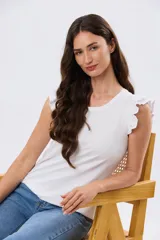Remera de algodón azul melange con escote redondo y mangas cortas adornadas con doble volado de broderie en los hombros.