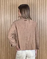 Sobrecamisa de puro lino en color beige, con cuello clásico, cierre frontal de botones carey, mangas largas y bolsillos frontales con solapa.