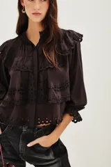 Camisa de algodón con diseño de encaje bordado, cuello mao, cierre frontal de botones y mangas largas con puños con volados.