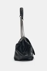 Bolso de hombro negro con detalle de costuras y tres compartimentos, uno con cierre de cremallera. Asa de hombro con cadena y cierre mediante imán.