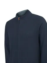 Cardigan de punto color azul marino, de manga larga, con cuello alto y cierre frontal completo con tirador de cuero. Presenta detalles de rayas en el interior del cuello.