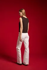 Top sin mangas de viscosa, de canalé y ajuste al cuerpo, con cuello a la base y cierre frontal de botones.